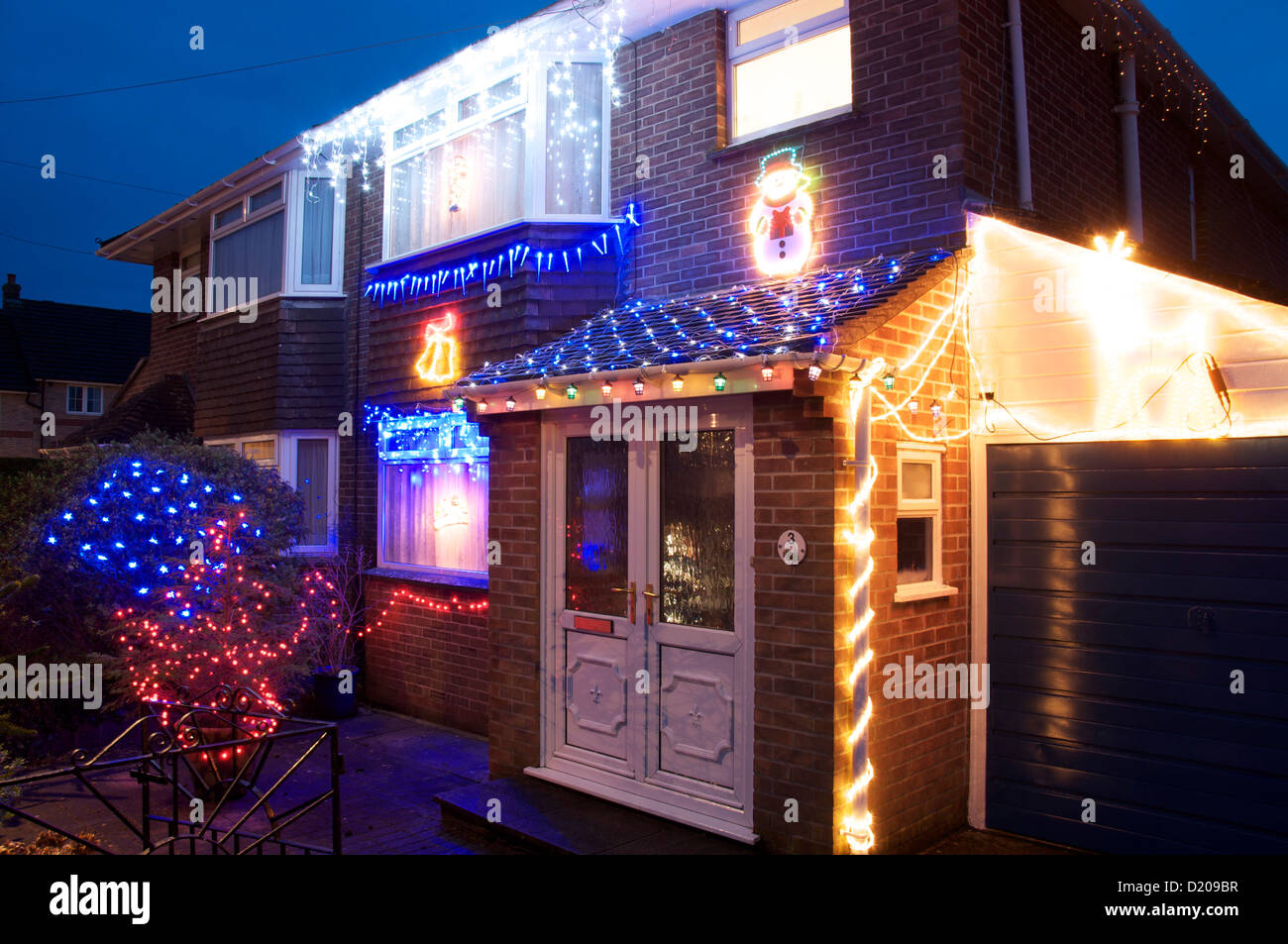 Xmas Illuminationen. Wie die lange Winternacht zieht, erhellen festliche Weihnachtsbeleuchtung dieses Doppelhauses in Dorchester, Dorset, England. VEREINIGTES KÖNIGREICH. Stockfoto