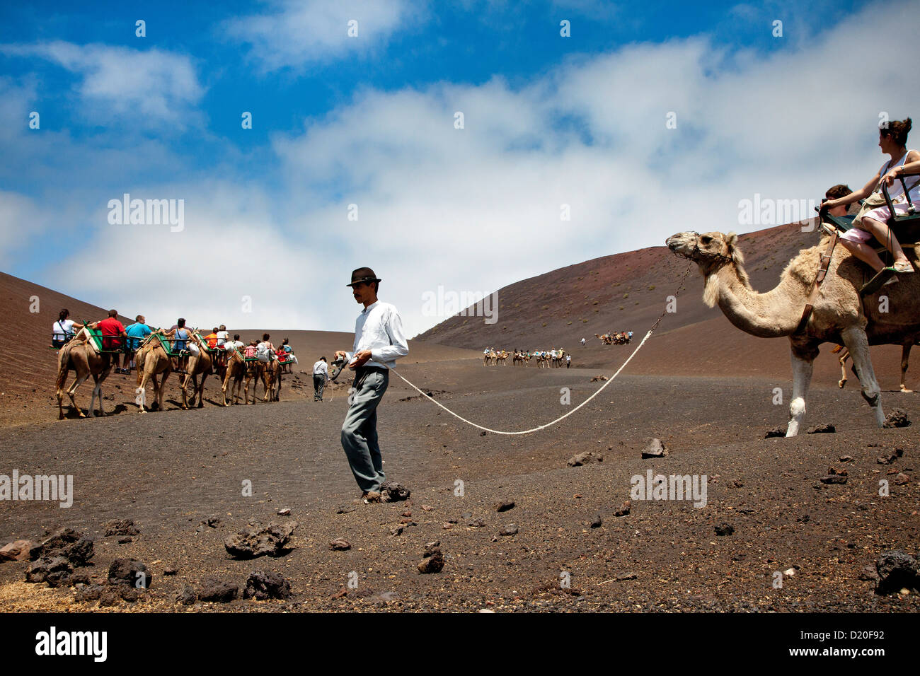 Menschen Kamelreiten in Vulkanlandschaft, Nationalpark Timanfaya, Lanzarote, Kanarische Inseln, Spanien, Europa Stockfoto