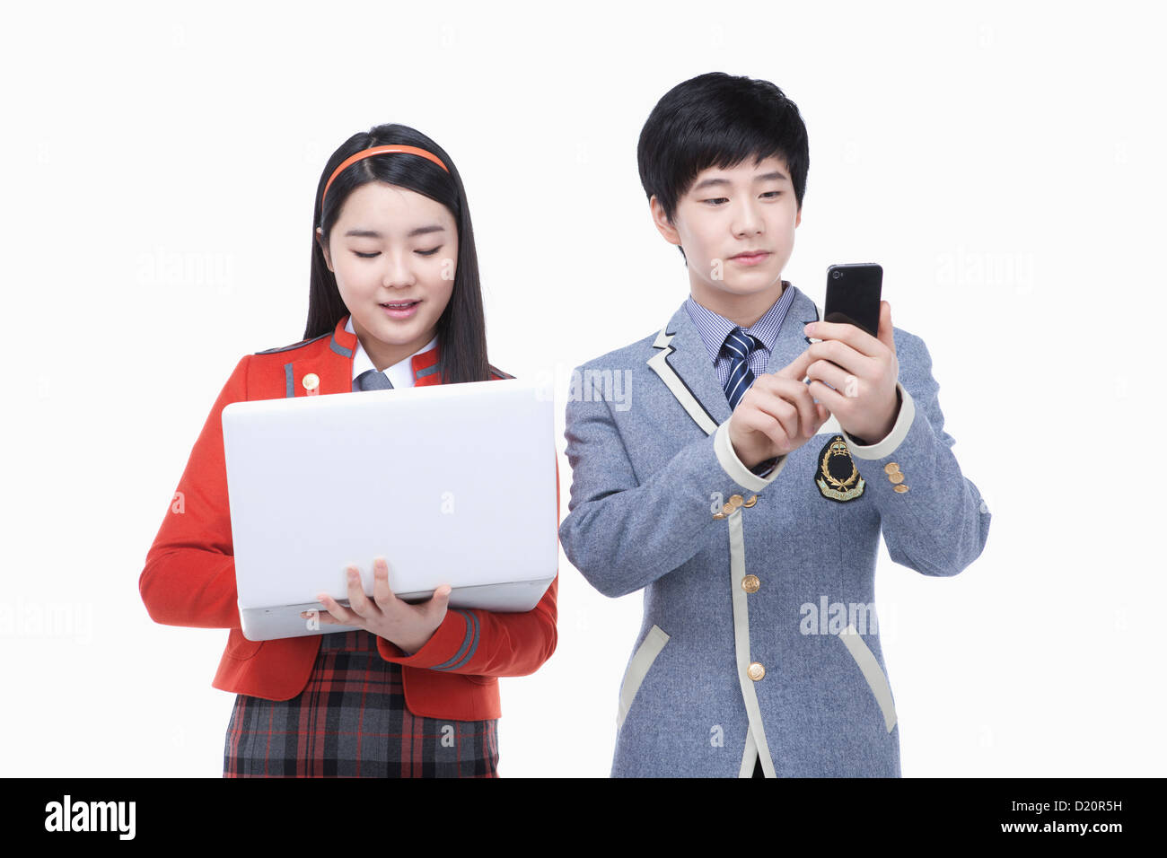 eine Studentin, die mit Laptop und männlichen Studenten, die mit dem Handy telefonieren Stockfoto