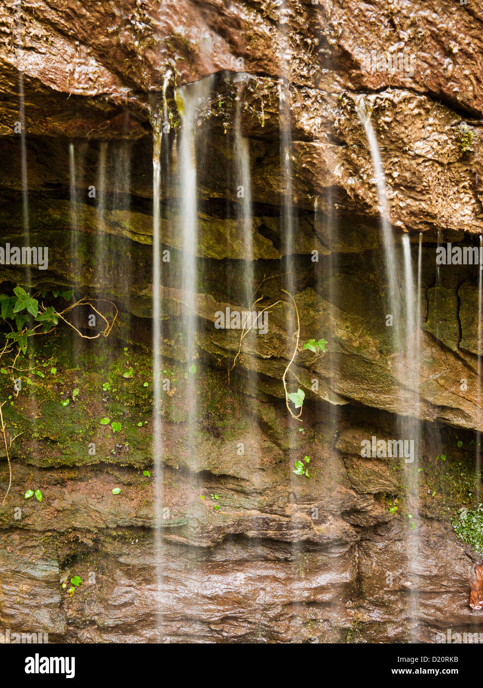 Kleiner Wasserfall über die Felsen auf einer Felswand Stockfoto