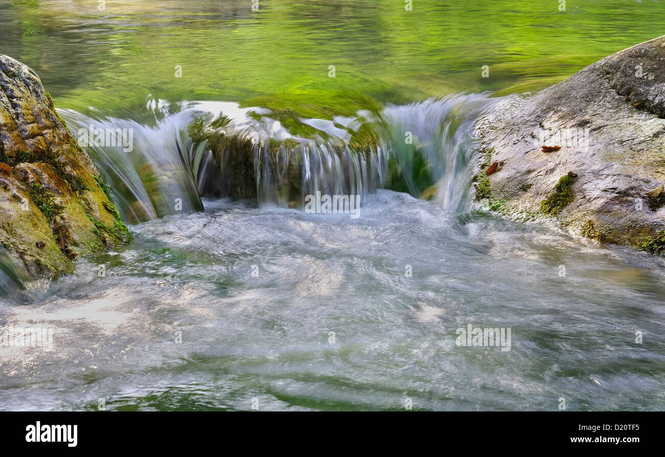klares Wasser eines Flusses fließt zwischen zwei Felsen Stockfoto