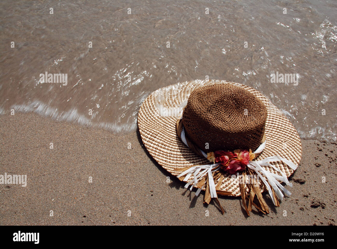 Strohhut mit am Strand ist von Meer Surf gewaschen Stockfotografie - Alamy