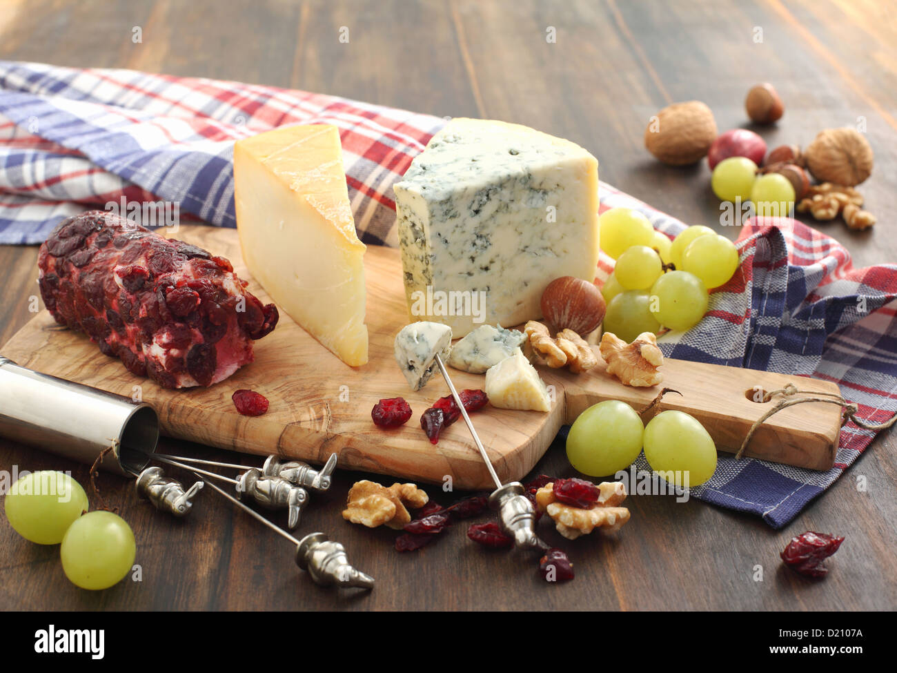 Käse vom Brett mit Trauben, getrocknete Preiselbeeren und Nüssen Stockfoto