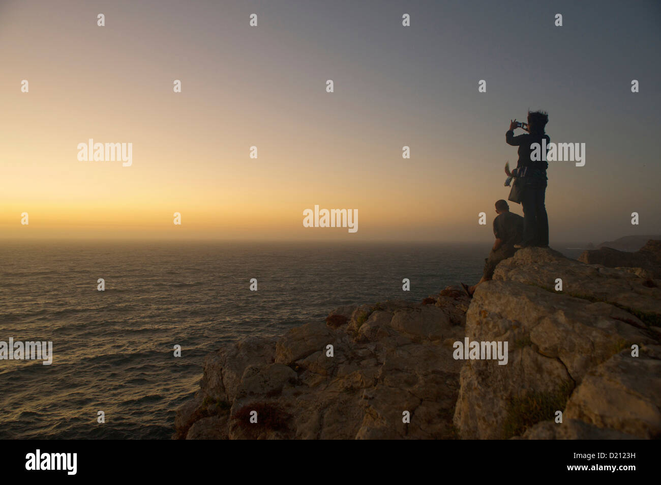 Zwei Menschen auf hohen Felsen über dem Atlantischen Ozean, Abendstimmung, Blick auf den Ozean, Cabo de Sao Vicente, Algarve, Portugal, Europa Stockfoto