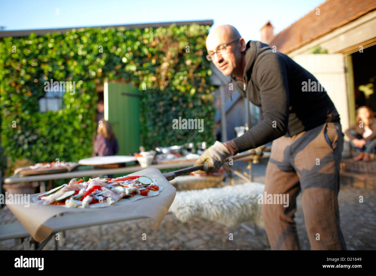 Mann mit Pizza auf ein Brot Schaufel, Klein Thurow, Roggendorf, Mecklenburg-Western Pomerania, Deutschland Stockfoto