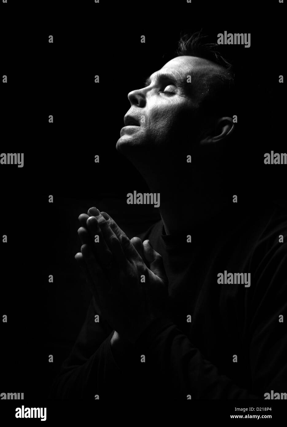 Kontrastreiche schwarz-weiß-Bild von einem Mann beten Stockfoto