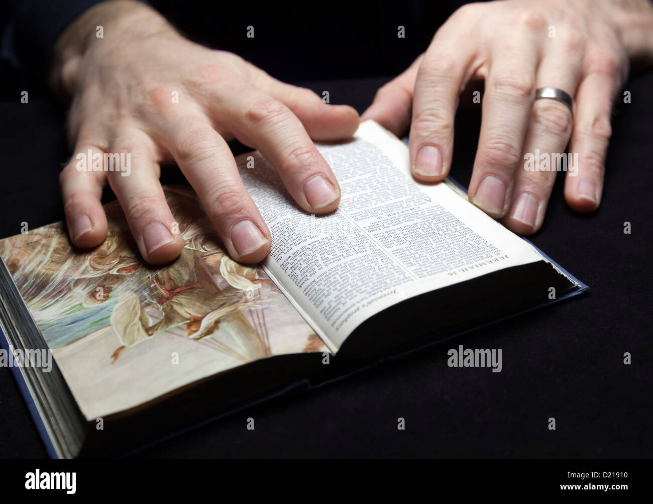 Ein Mann liest die Bibel mit beiden Händen. Stockfoto