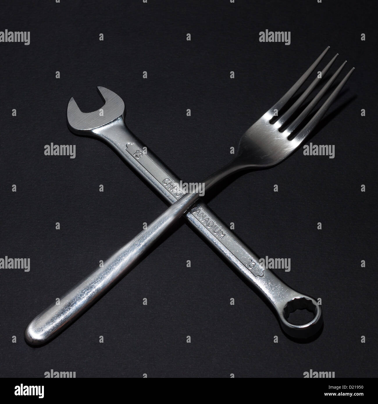 Stillleben mit Gabel und Schraubenschlüssel auf schwarzem Hintergrund Stockfoto