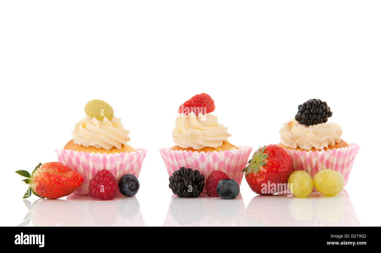 Obst-Cupcakes mit Buttercreme und frischen Früchten isoliert auf weißem Hintergrund Stockfoto