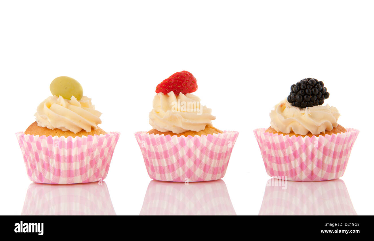 Cupcakes mit Buttercreme und frischen Früchten isoliert auf weißem Hintergrund Stockfoto