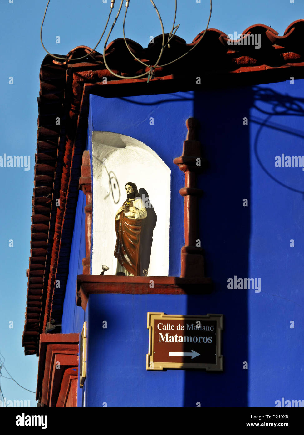 einfache weiße Nische schneiden in der Ecke des blaues Gebäude als Schrein für Jesus-Figur mit Draht Schatten darauf hindeutet Schlinge Oaxaca Mexico Stockfoto