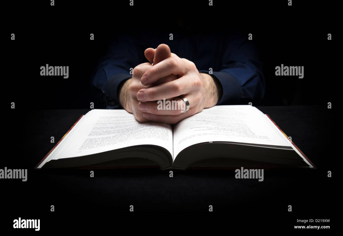 Mann mit seinen Händen ruht auf eine Bibel zu Gott zu beten. Stockfoto