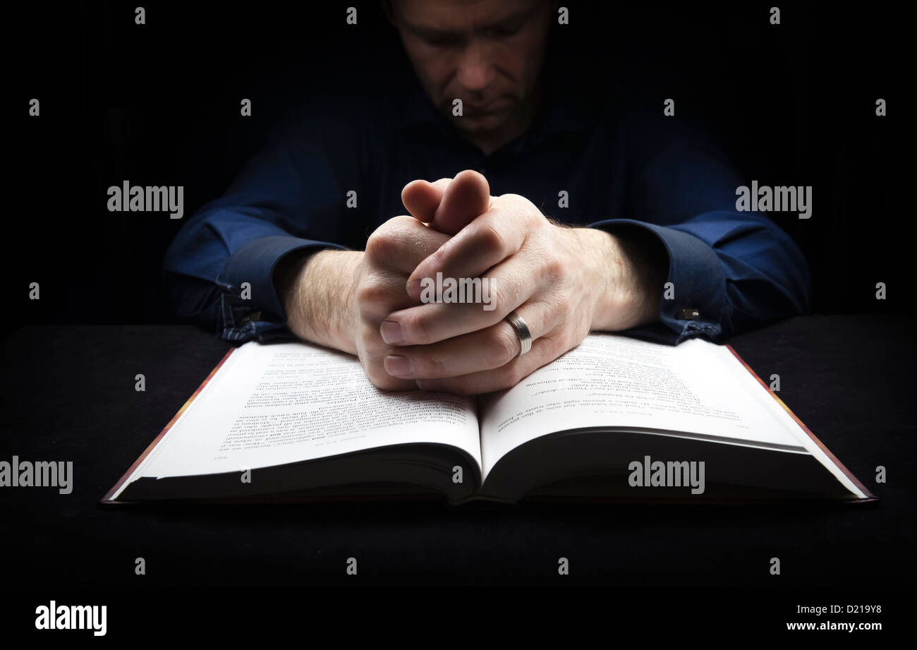 Mann mit seinen Händen ruht auf eine Bibel zu Gott zu beten. Stockfoto