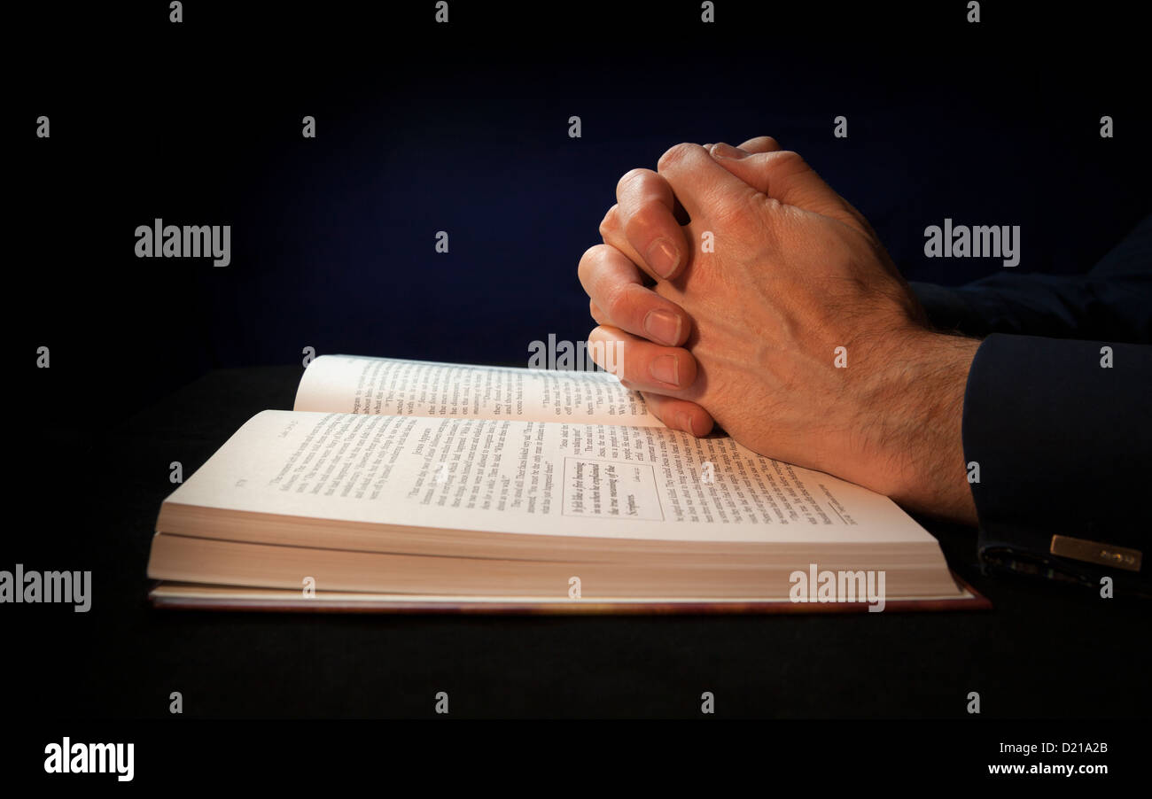 Gefalteten Händen auf eine Bibel während des Betens zu Gott. Stockfoto