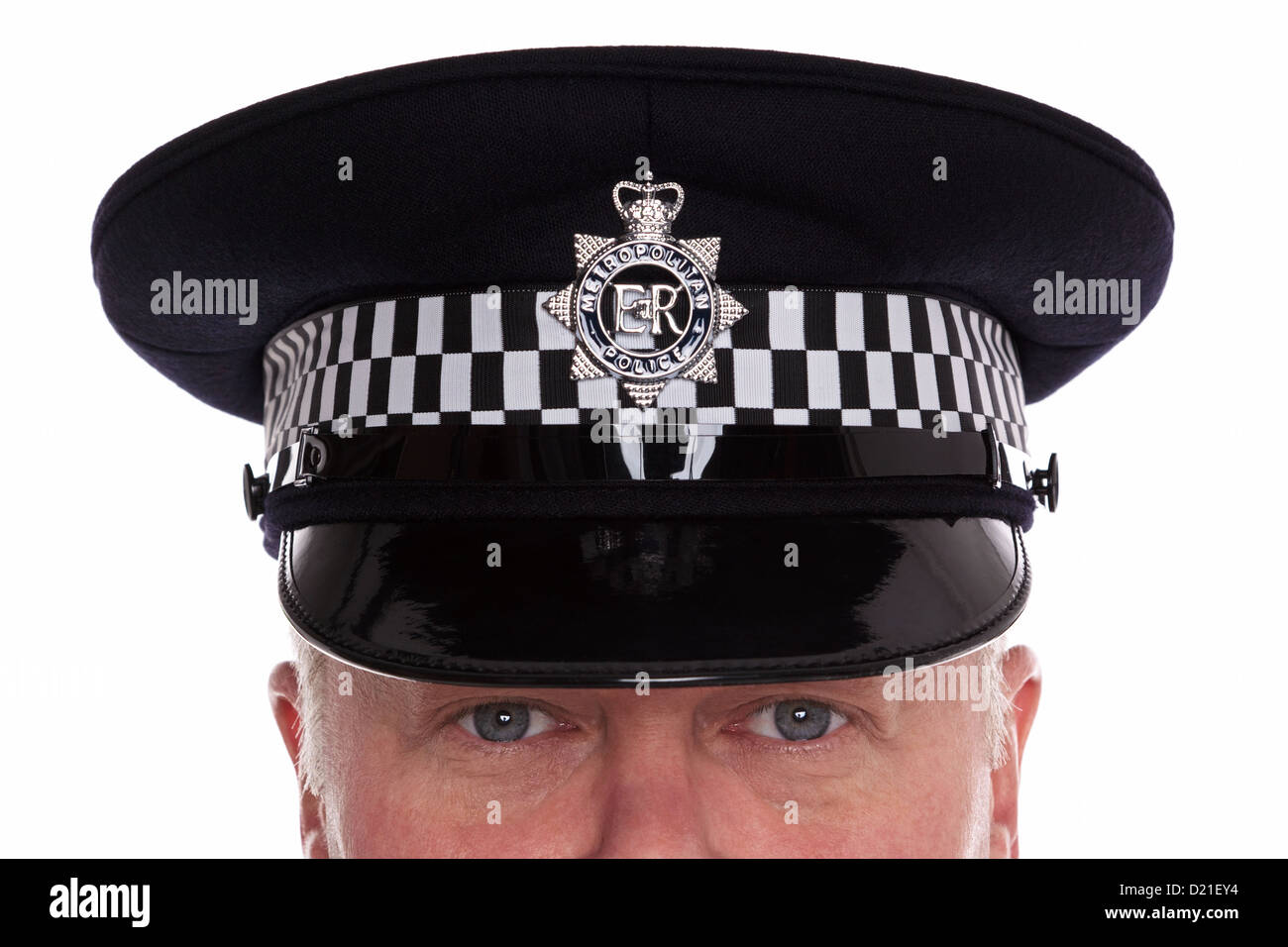 Nahaufnahme eines britischen Polizisten tragen eine flache Kappe mit seinen Augen beobachtete Sie, Studio gedreht. Stockfoto