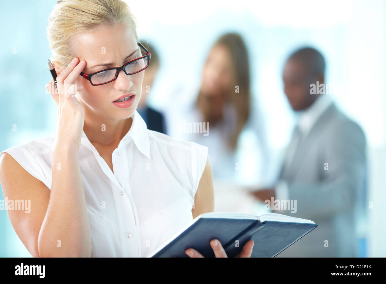 Schöne Büro-Dame, die versuchen, ihre Pläne für den Tag erinnern Stockfoto