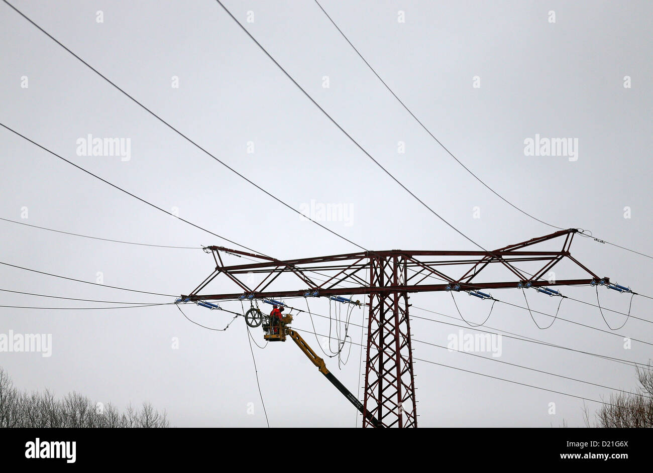 Arbeiter der EnviaM arbeiten auf einem 110.000-Volt-Overhead-Trasse bei Espenhainer, Deutschland, 9. Januar 2013. Sie übertragen die Pole für 50-100m und auch die Stromleitung durch Baupläne von der Autobahn (A 72) zu erneuern. Foto: Jan Woitas Stockfoto