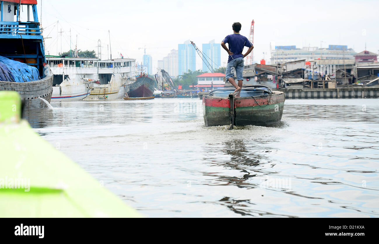 Begriffliches menschliches Porträt eines Fischers, der in seinem Boot steht und der Stadt zugewandt ist Stockfoto