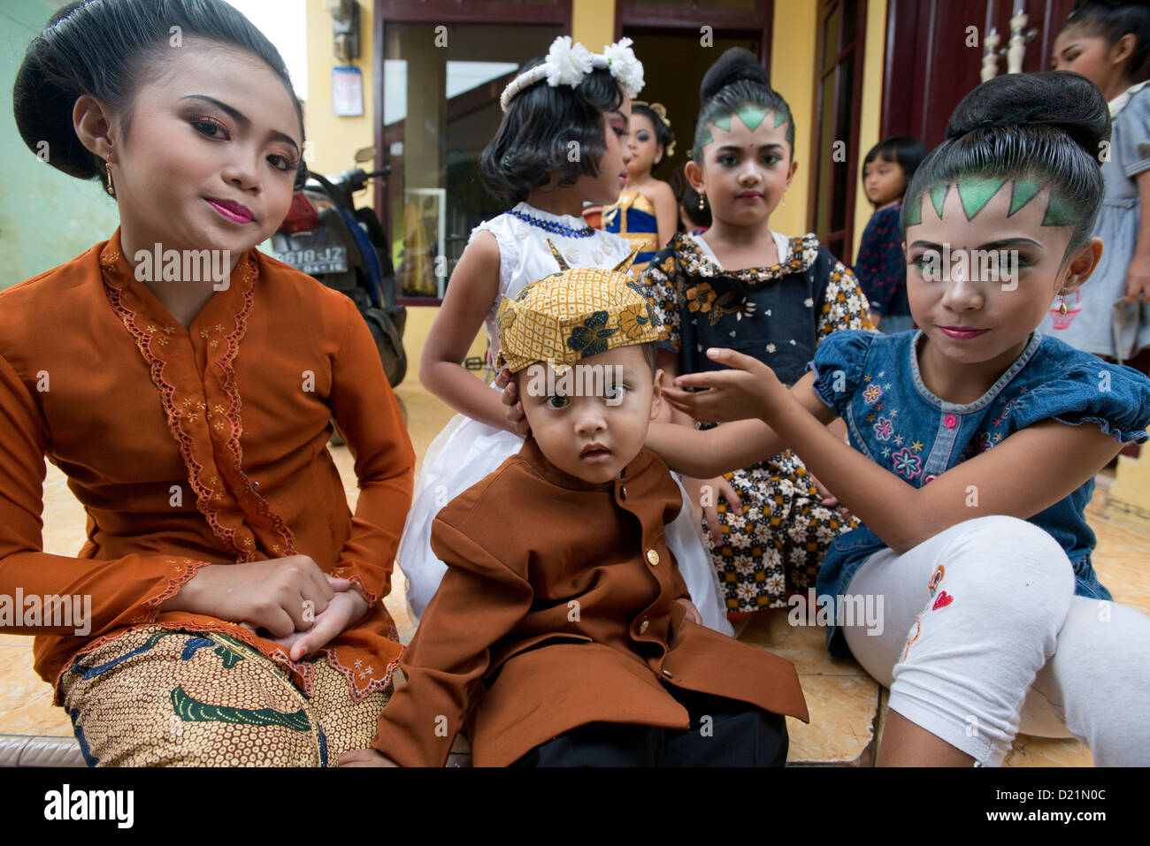 Eine Gruppe von jungen Kindern erwarten den Abfall von einem Erntedankfest Parade im Dorf Tumpang, Java, Indonesien Stockfoto