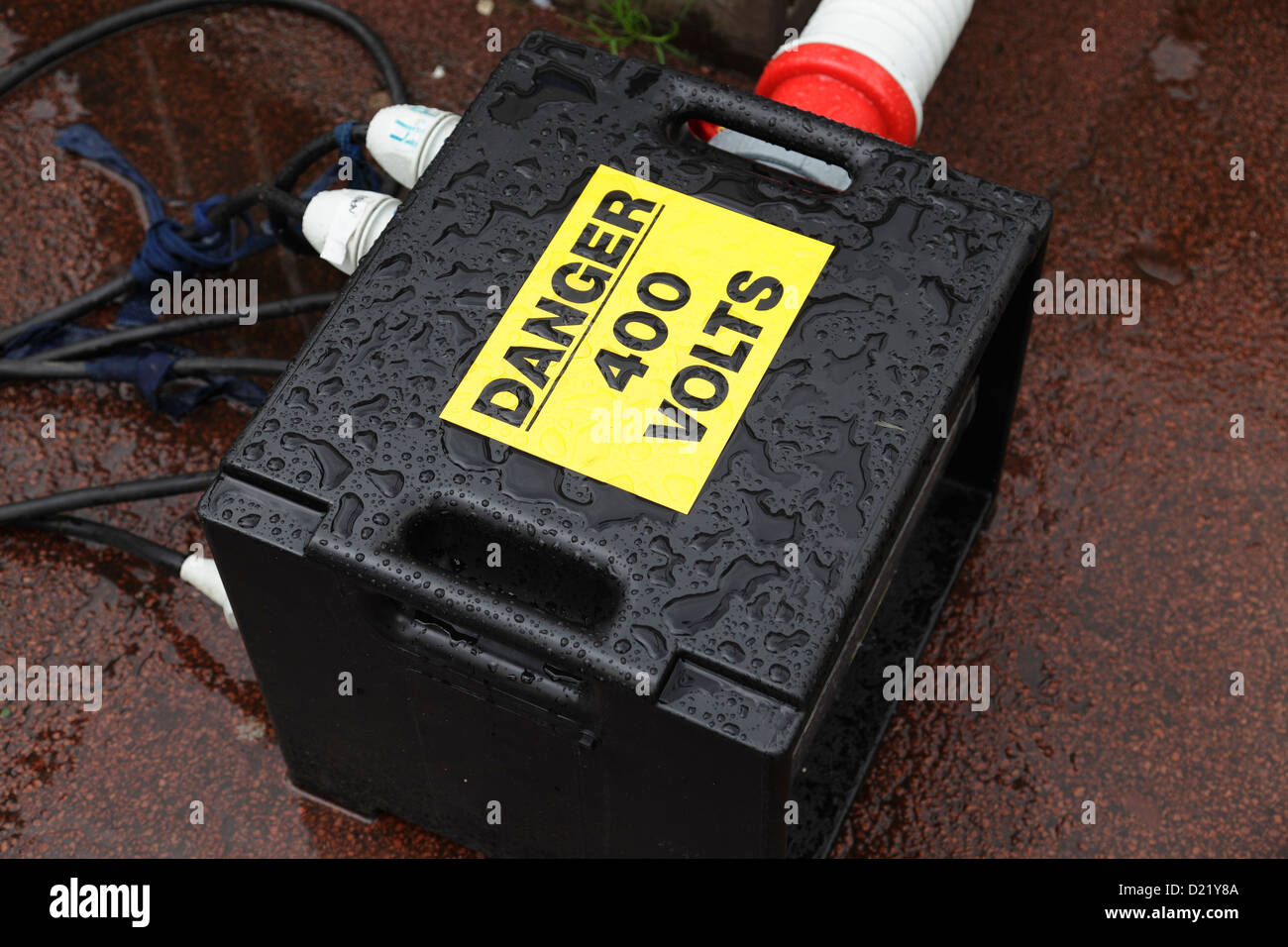 Gefahr 400 Volt Zeichen auf einem sehr nassen Stromverteilerkasten in Verwendung bei einem Outdoor-Event, Großbritannien Stockfoto