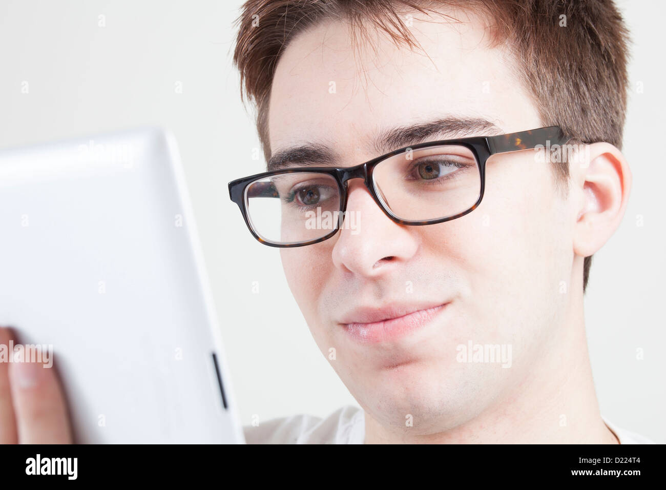 Junger Mann mit Brille auf den Bildschirm seines Laptops oder digital-Tablette. Hautnah. Stockfoto