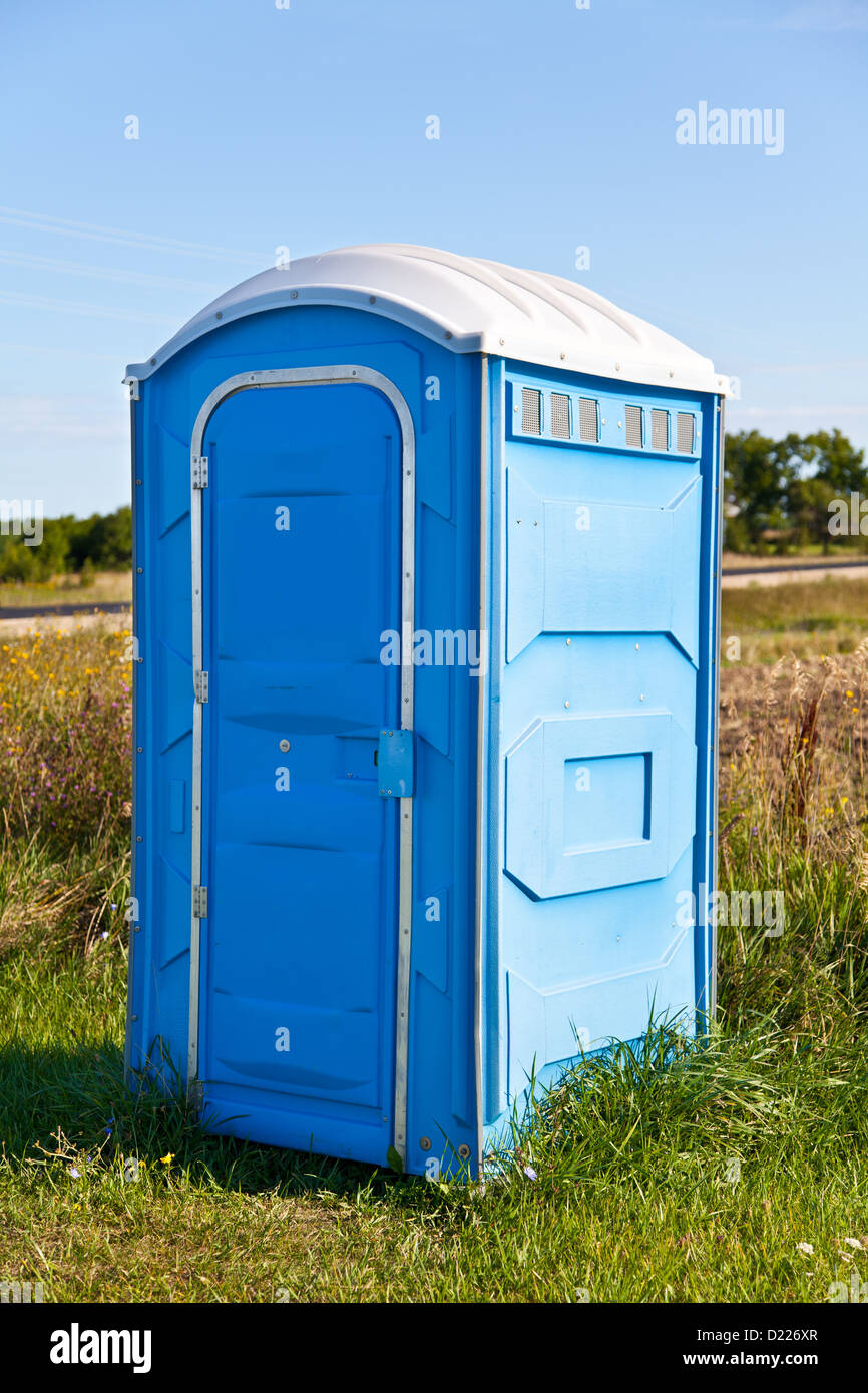Eine blaue tragbare Toilette in den Rasen. Stockfoto