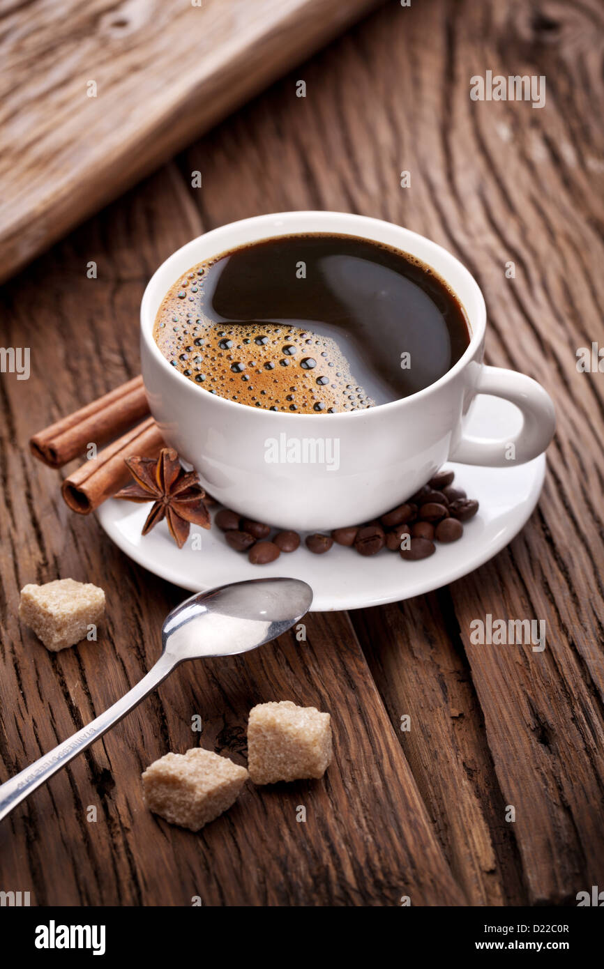 Tasse Kaffee mit braunem Zucker auf einem Holztisch. Stockfoto