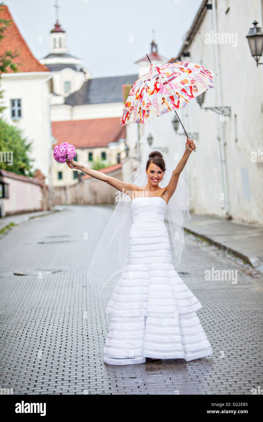 Junge Braut an ihrem Hochzeitstag im Regen Stockfoto