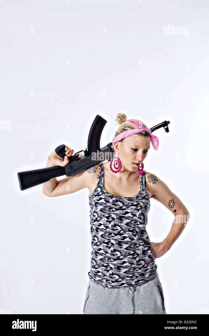 Gefährliche junge Frau mit automatischen Gewehr Stockfoto