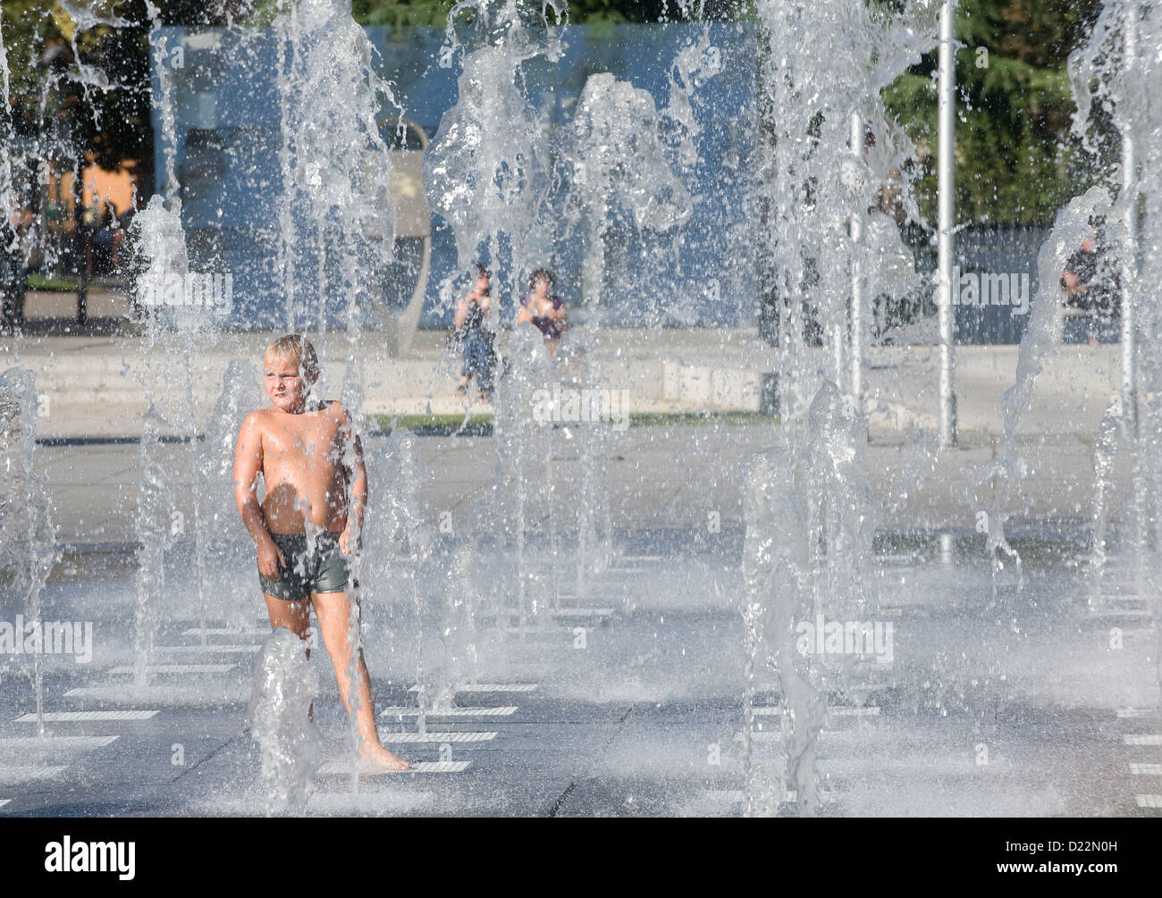 Colmar, Frankreich, kühlt sich ein Kind in ein Wasserspiel Stockfoto