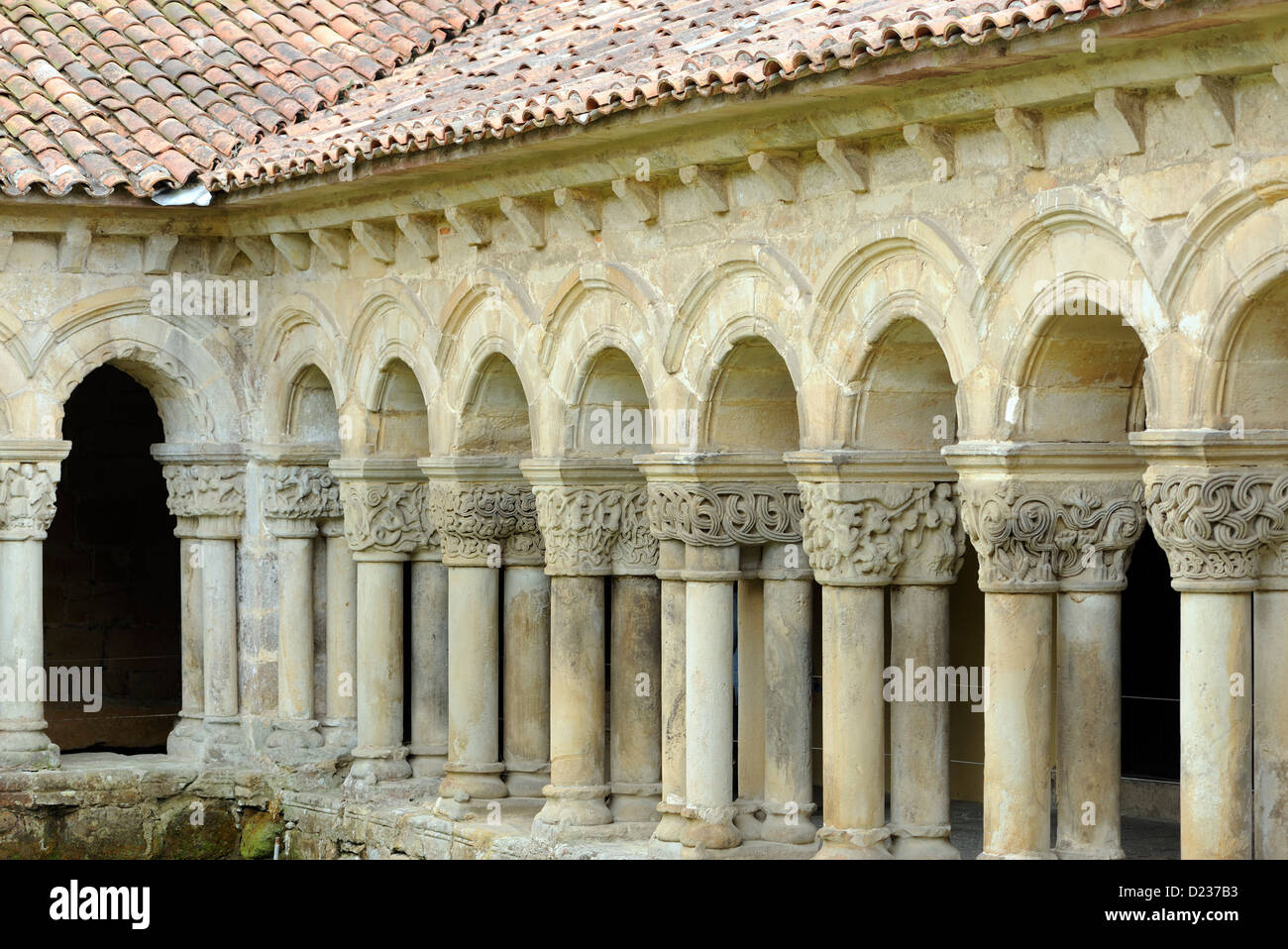 Intracately geschnitzte Kapitelle auf Säulen, die Bögen dieser Form Kolonnade des romanischen Colegiata Santillana del Mar Stockfoto