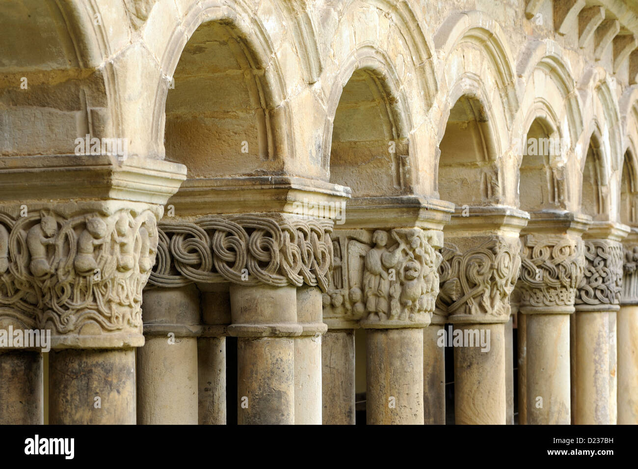 Intracately geschnitzte Kapitelle auf Säulen, die Bögen dieser Form Kolonnade des romanischen Colegiata Santillana del Mar Stockfoto