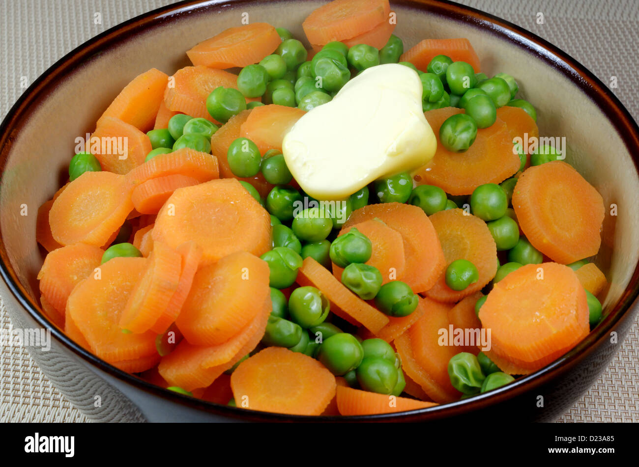 Frische Erbsen und Karotten in einer Schüssel Stockfoto