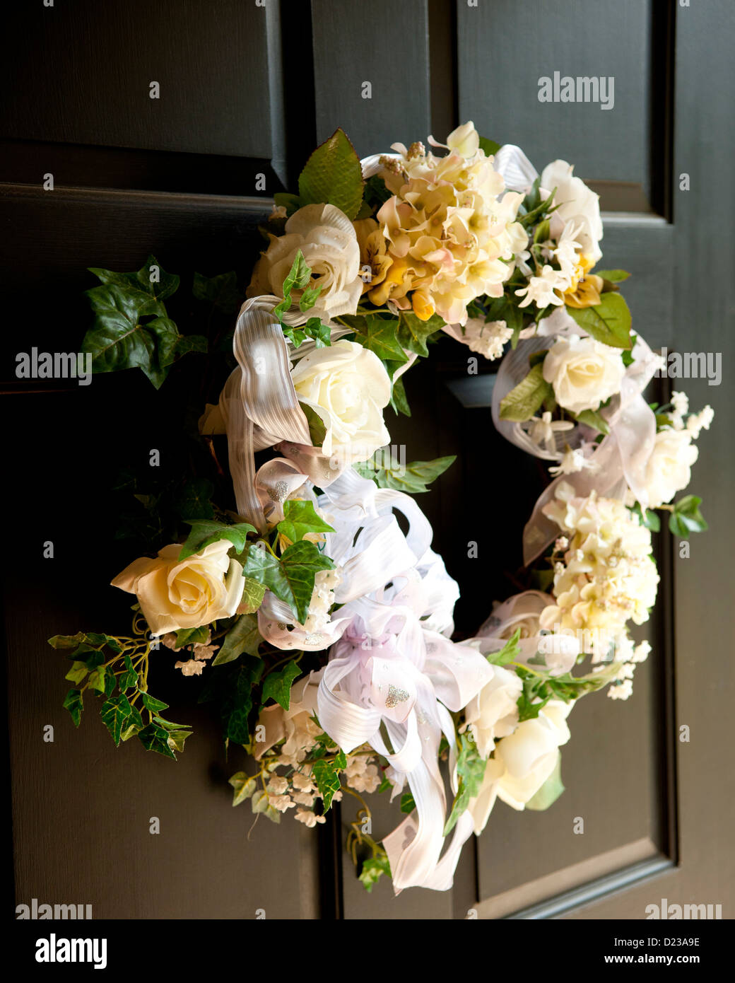 Ein Kranz aus weißen Blüten auf einem schwarzen Tor, Hochzeit Girlande Stockfoto