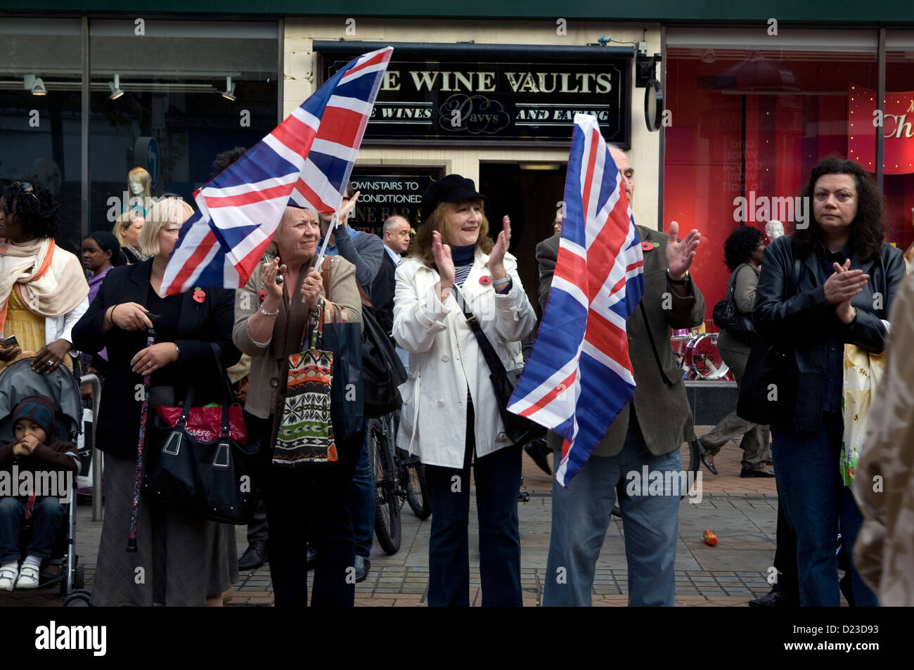 Eine Menge Leute jubeln und winken Union Jack Flagge bei einer Militärparade. Stockfoto
