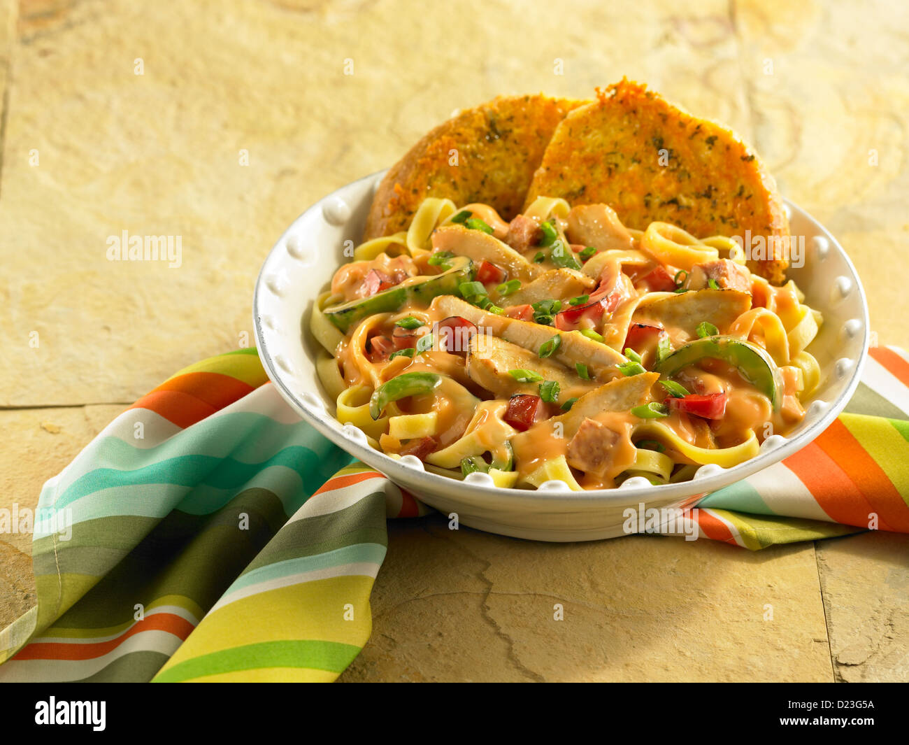 Chicken Pasta in einer cremigen Sauce serviert mit Knoblauchbrot Stockfoto
