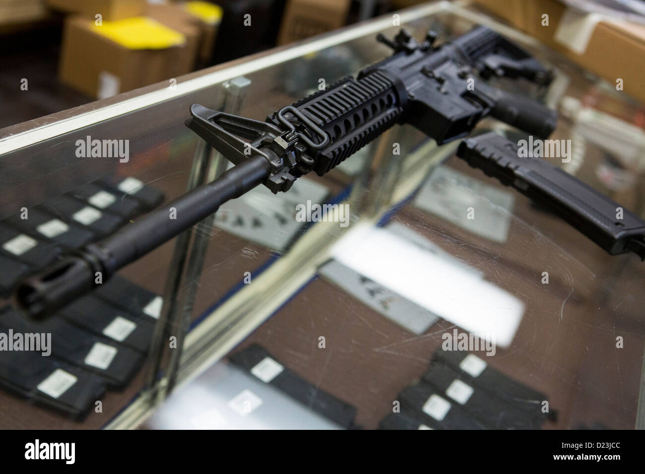 Ein Colt Defense M4A1 Karabiner Sturmgewehr auf dem Display auf ein Waffengeschäft mit hoher Kapazität 30 Runde Zeitschriften. Stockfoto