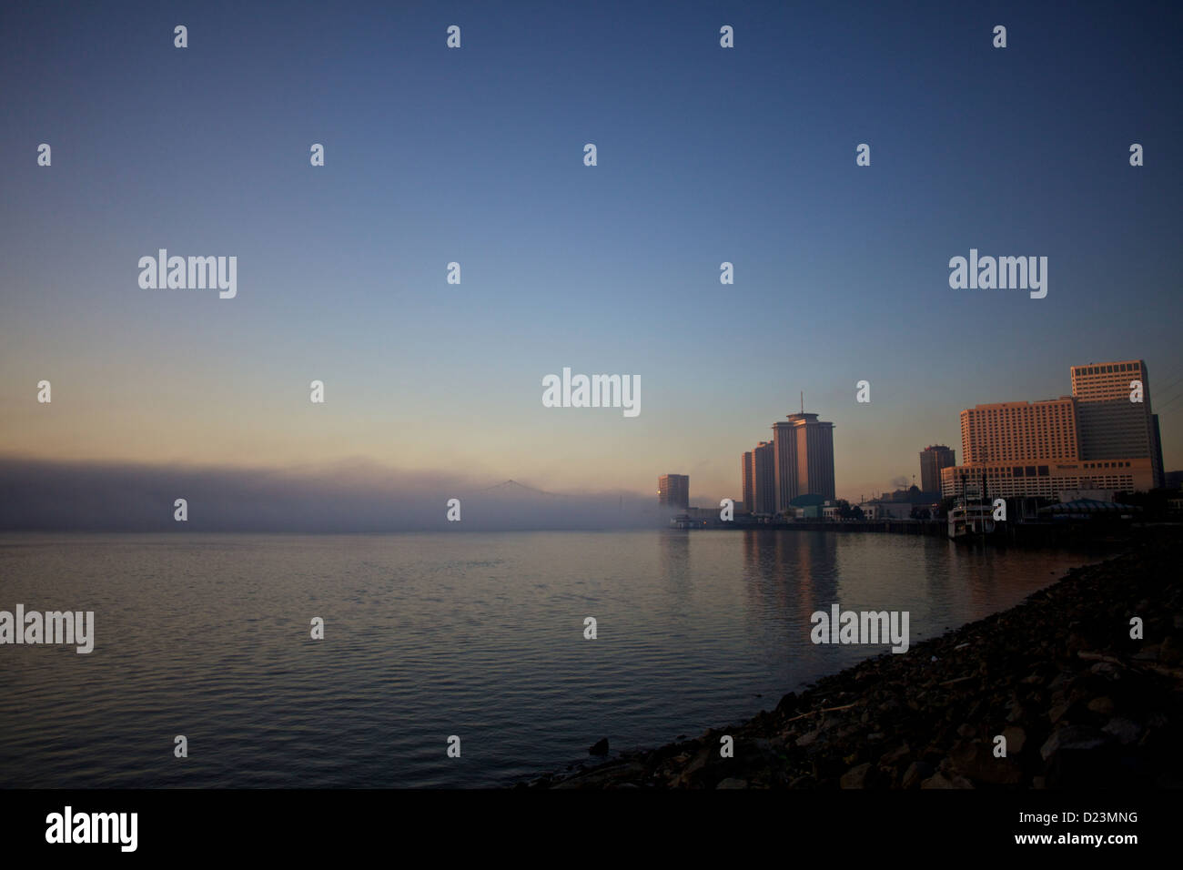 Sonnenuntergang über der Skyline von New Orleans mit sanften Blau- und Orangetönen, die sich auf dem Mississippi River spiegeln Stockfoto