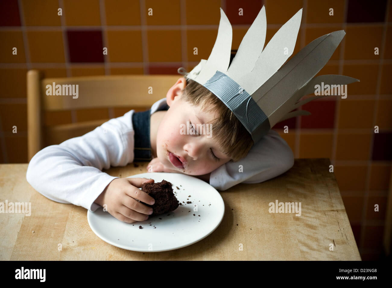 Berlin, Deutschland, schlief junge mit indischen Kopfschmuck während des Essens Stockfoto