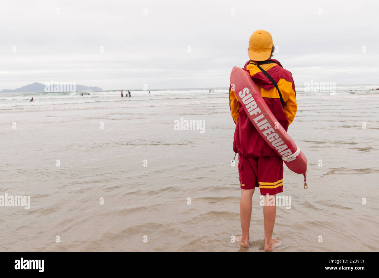 Ein junger Rettungsschwimmer Leute im Wasser zu beobachten. Stockfoto