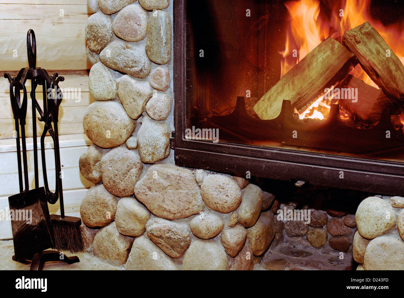 Gemütliches Feuer in einem Kamin aus Naturstein Stockfoto