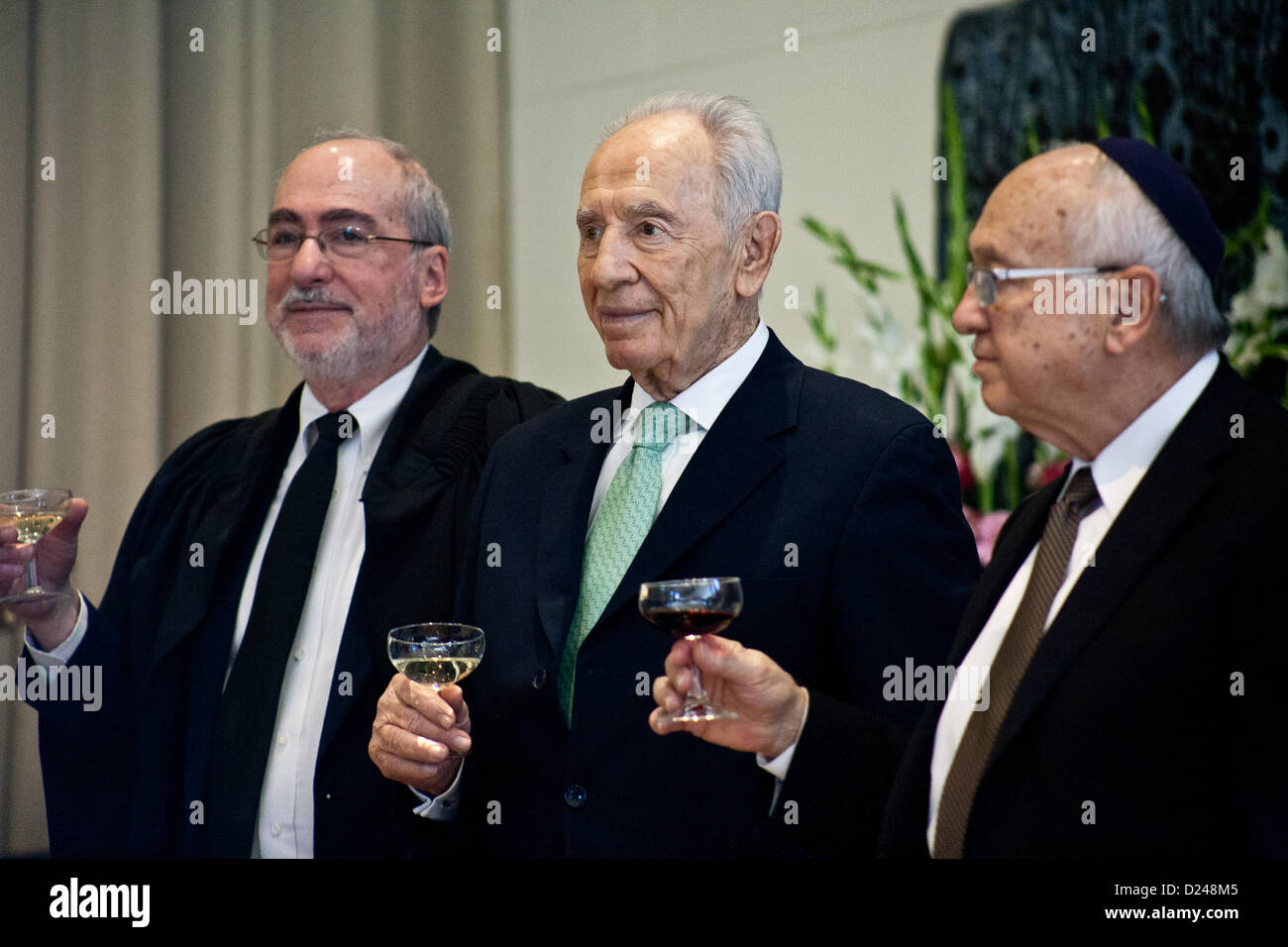 Jerusalem, Israel. 14. Januar 2013. Präsident Shimon Peres (Mitte), Justizminister Yaakov Neeman (rechts) und Supreme Court und High Court of Justice Präsident Asher Grunis (links) stoßen Sie den Erfolg der neu ernannte Richter im Rahmen einer Feierstunde in der Residenz des Präsidenten. Jerusalem, Israel. 14. Januar 2013.  Präsident Shimon Peres gewährt Ernennungsschreiben zwölf neue Richter am Presidents Residenz im Beisein von Justizminister Ya'akov Ne'eman und Honorable Asher Grunis, Präsident des Obersten Gerichts und der High Court of Justice. Stockfoto