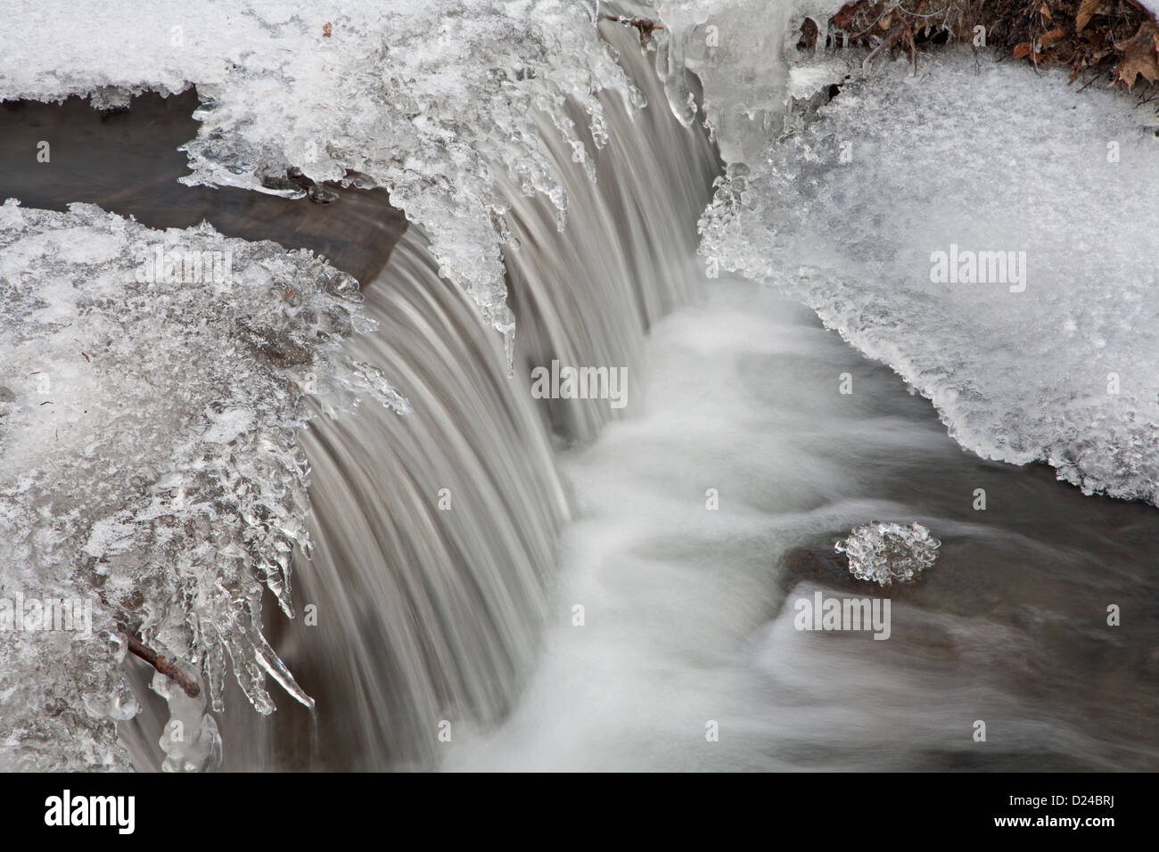 kleiner Wasserfall und Eiszapfen vom Winter creek Stockfoto