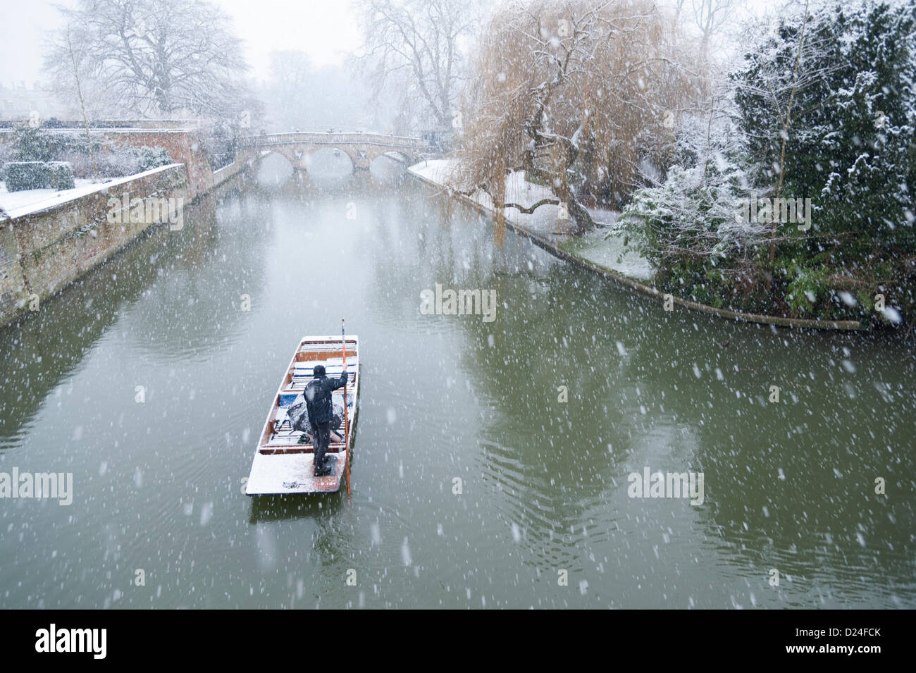 Cambridge UK 14. Januar 2013.  Touristen gehen auf dem Fluss Cam in starkem Schneefall Stechkahn fahren. Dicken Schnee fiel im Laufe des Nachmittags in East Anglia und Touristen genießen die Winterlandschaft auf dem Rücken von den pädagogischen Hochschulen trotz des Wetters. Sie geschützt unter Schirmen, während ihr Chauffeur Punt ihnen eine geführte Tour gab. Stockfoto