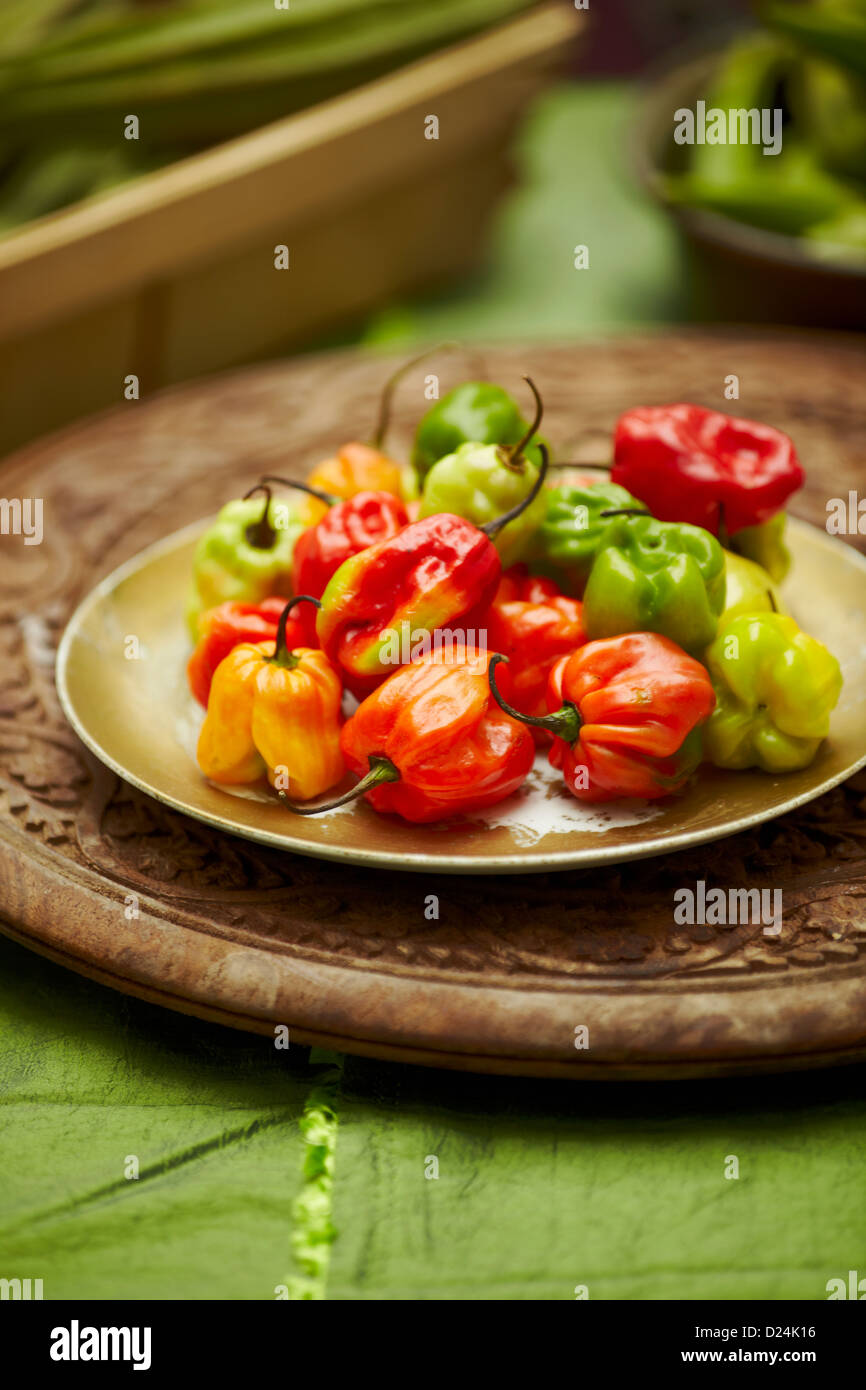 Eine Platte von Scotch Bonnet Peppers auf einem geschnitzten Holzbrett Stockfoto