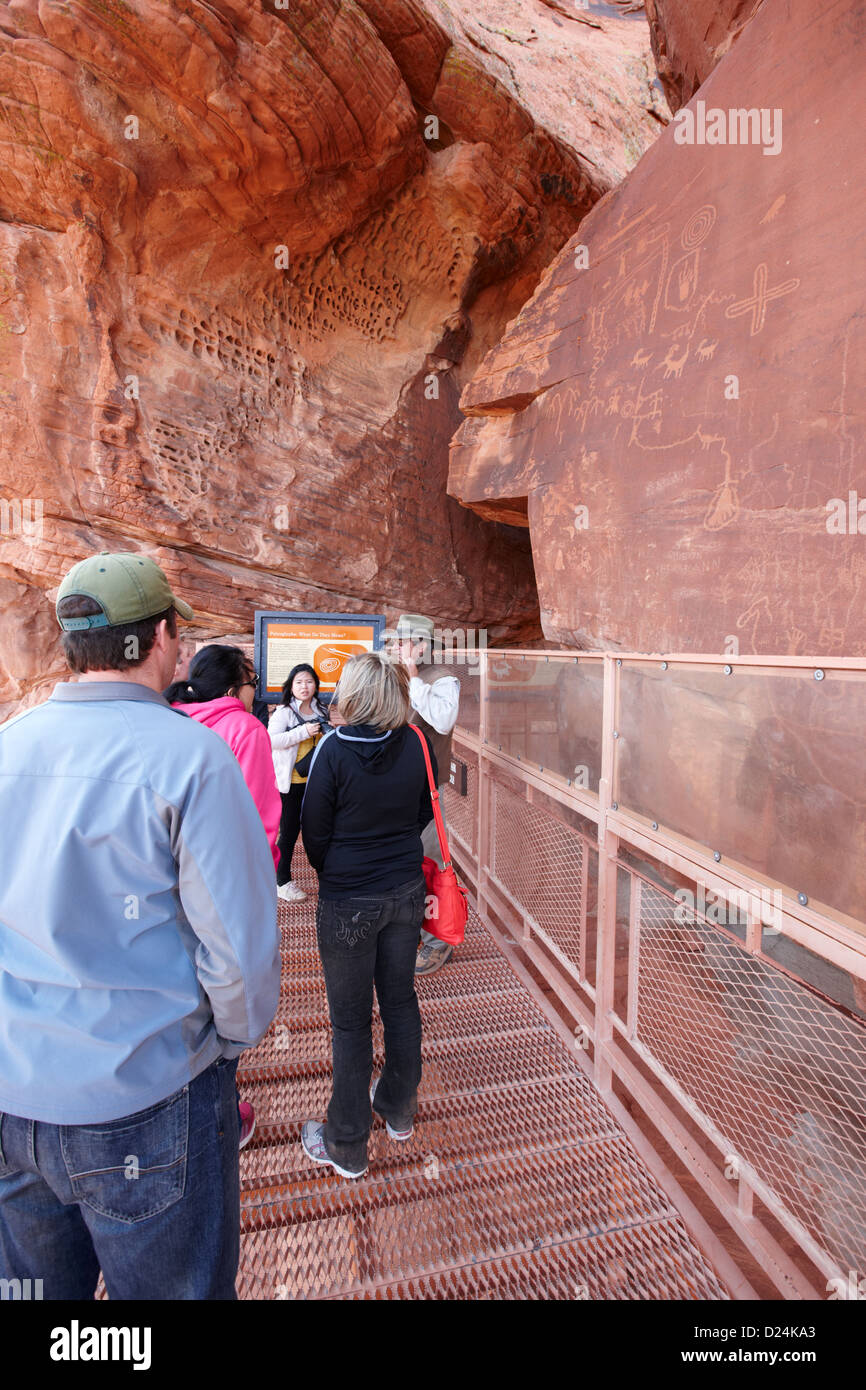 Touristen auf der Aussichtsplattform vor Petroglyphen auf Atlatl großen Felsen Tal des Feuers Staatspark Nevada, usa Stockfoto