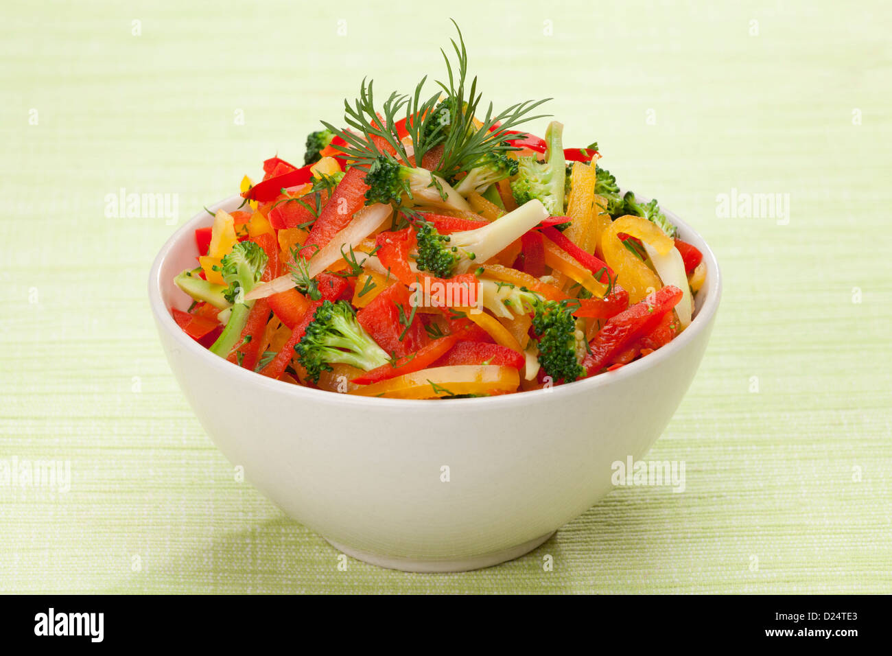 rote, gelbe und orange süße Paprika, Brokkoli und Fenchel-Salat auf grünen Leinwand Hintergrund Stockfoto