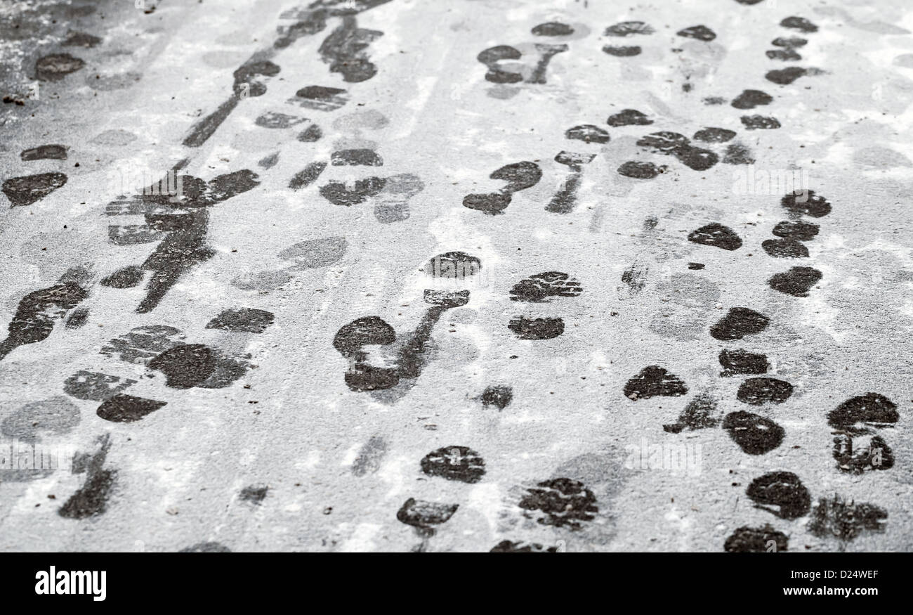 Spuren im nassen Neuschnee auf städtischen Asphaltstraße Stockfoto