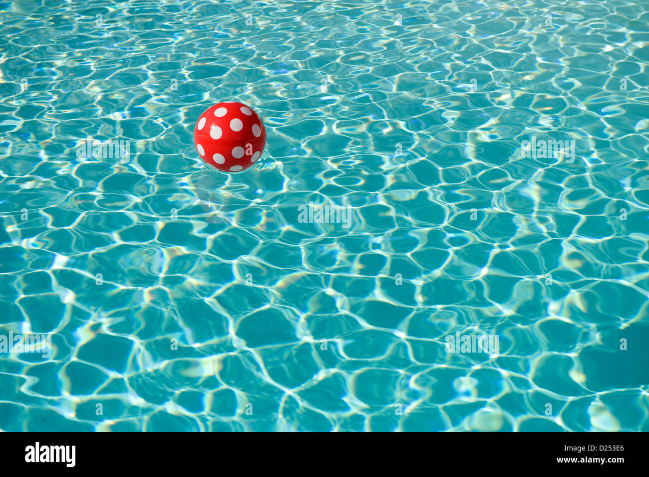 Vacqueyras, Frankreich, eine rot-weiß gepunktete Kugel in einem Schwimmbad Stockfoto