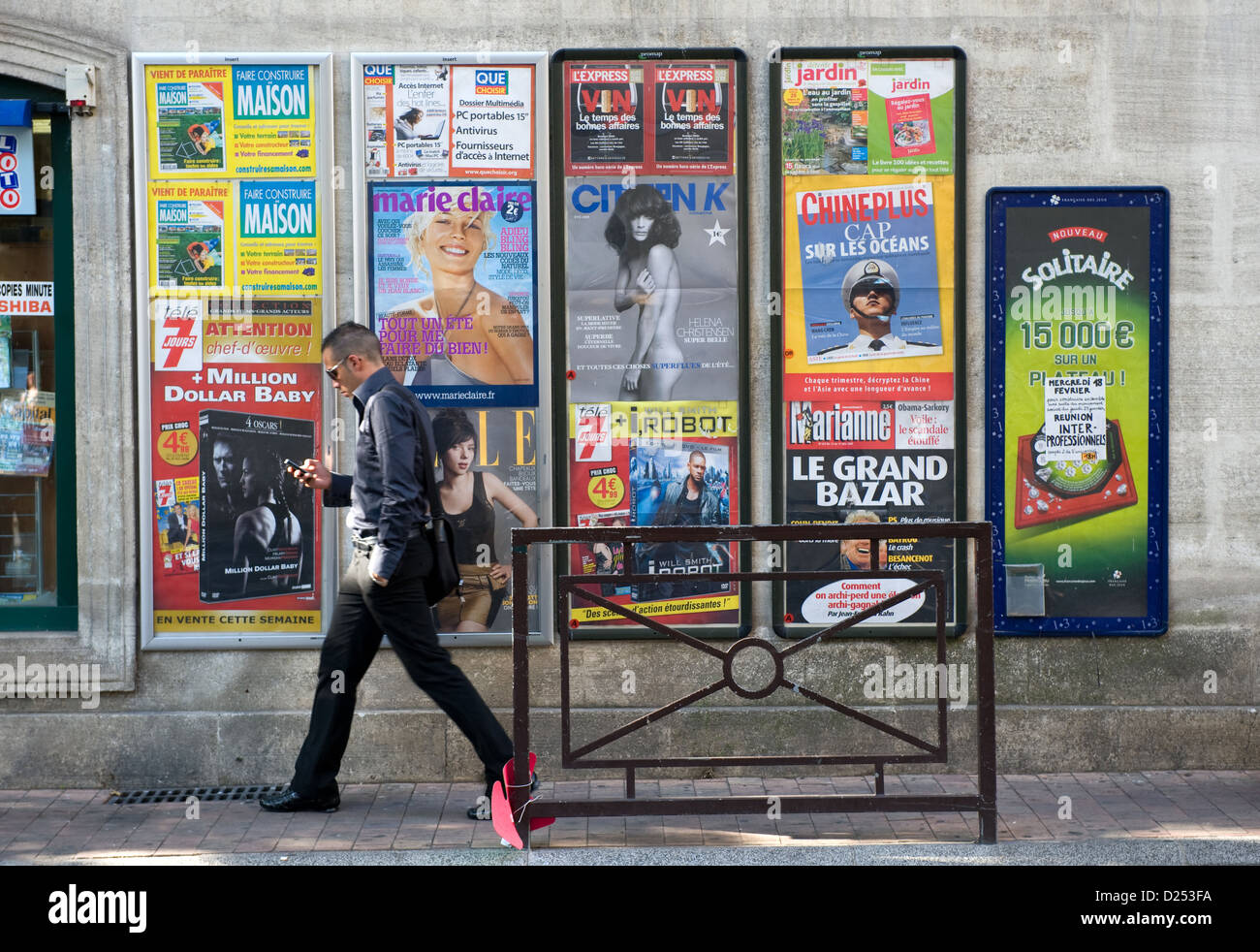 Avignon, Frankreich, geht ein Mann eine Wand mit Plakaten Stockfoto